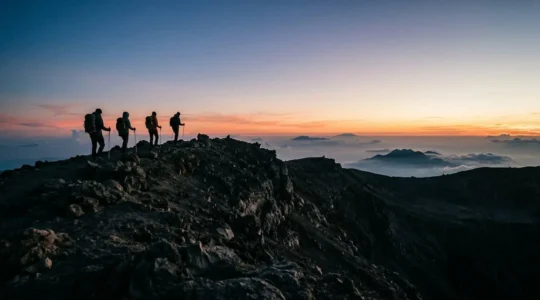 Randonneurs observant le lever du soleil depuis le cratère volcanique avec vue panoramique sur les coulées de lave