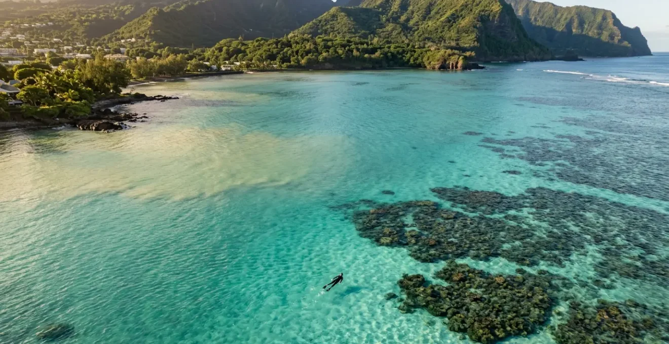 Vue aérienne du lagon turquoise de La Réunion avec nuances colorées montrant l'impact invisible des polluants