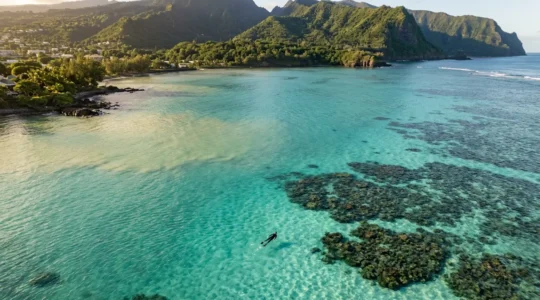 Vue aérienne du lagon turquoise de La Réunion avec nuances colorées montrant l'impact invisible des polluants