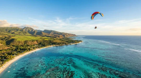 Vue aérienne d'un parapentiste survolant le lagon turquoise de Saint-Leu à La Réunion