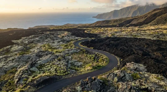 Vue aérienne de la route des laves traversant des coulées volcaniques successives à La Réunion.
