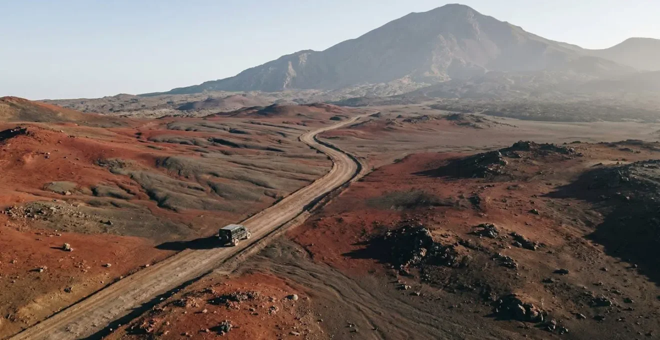 Paysage lunaire de la Plaine des Sables traversé par une piste ocre au milieu des scories volcaniques