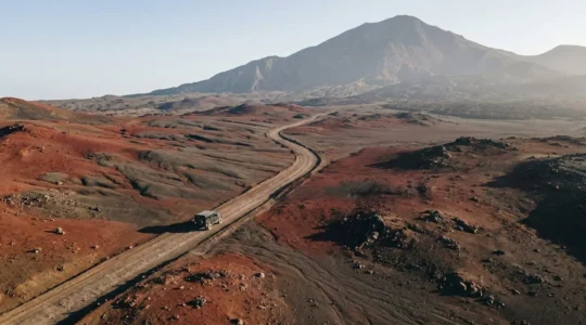 Paysage lunaire de la Plaine des Sables traversé par une piste ocre au milieu des scories volcaniques