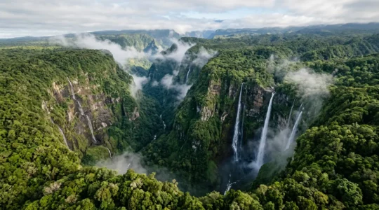 Vue aérienne spectaculaire du Trou de Fer à La Réunion avec ses cascades de 700 mètres plongeant dans le gouffre entouré de végétation tropicale