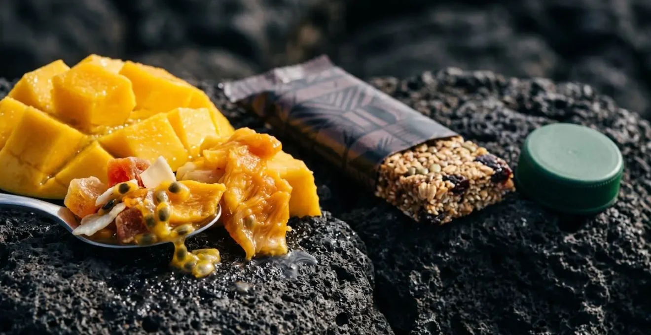 Composition nutritionnelle pour randonnée avec fruits locaux et barres énergétiques sur rocher volcanique
