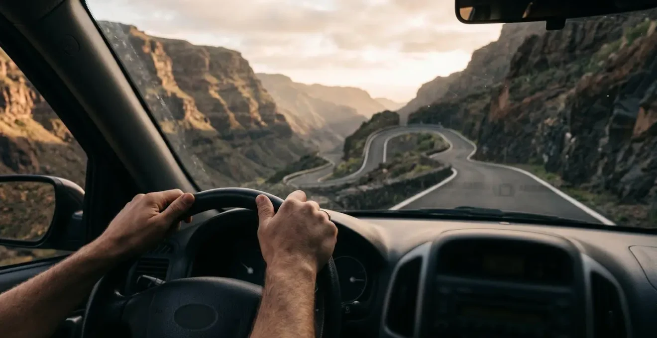 Route sinueuse de montagne à La Réunion vue depuis l'habitacle avec focus sur le volant et les virages